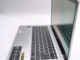 a silver laptop with a black keyboard on a white surface