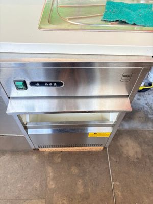 a stainless steel counter top oven with a green towel on it