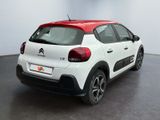 the rear end of a white and red citrole parked in a room