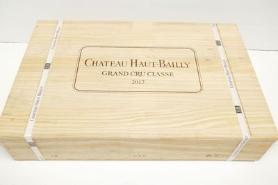 une boîte en bois sur laquelle est apposée une étiquette portant la mention « Château Hau-Bally Grand Cru Classé »
