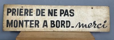 un panneau posé sur un support en bois sur lequel on peut lire « Prére de ne pas monter à bord » Morel