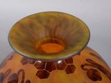 a vase that has a yellow and brown design on it