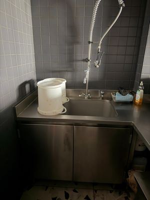 un évier situé dans un coin de la cuisine, équipé d'un robinet