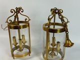 pair of brass and glass lanterns with a bell on each of them