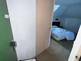 une chaise dans un coin de la pièce, à côté d'un lit