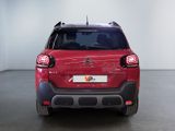 the rear end of a red citrole parked in a white room