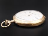 an antique gold pocket watch with a chain on a black background