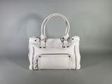 a white handbag sitting on top of a gray surface