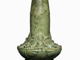 a green vase that is sitting on a white surface