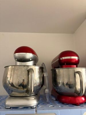 deux mixeurs rouges posés sur une étagère bleue