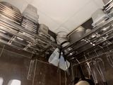 many pots and pans hanging from the ceiling in the kitchen