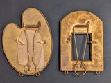 two pieces of gold metal with a metal pin and a metal pin