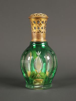 une bouteille en verre vert avec un bouchon doré, posée sur une surface grise