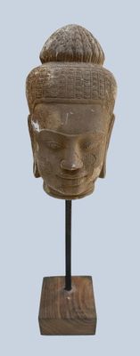 sculpture of a head on a wooden stand with a light blue background