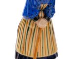 figurine représentant une vieille femme avec un balai, sur fond blanc