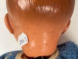 a doll head that is wearing a blue and white sweater