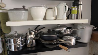 de nombreuses casseroles et poêles sur les étagères de la cuisine