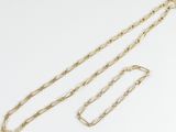 a close up of a gold chain with a clasp on a white background