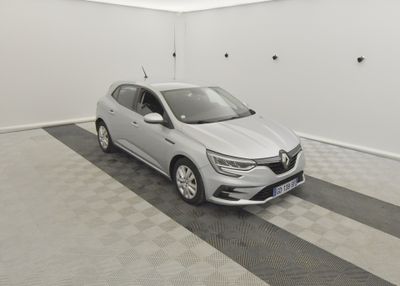 Une voiture grise est garée dans une pièce blanche au sol à carreaux.