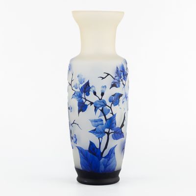 un vase blanc orné de fleurs bleues sur fond blanc