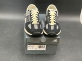 pair of black and white sneakers with yellow laces on top of a box