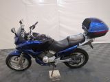a blue motorcycle that is parked on a checkered floor
