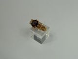 a close up of a gold ring with a brown stone on it