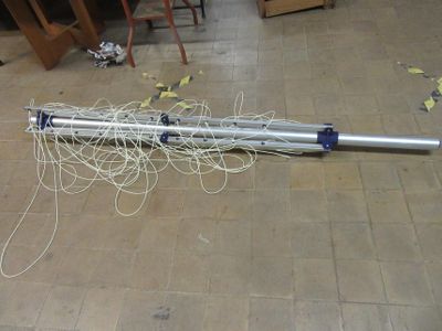 a metal pole with wires on the floor in a room