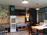 a room with a table, chairs and a refrigerator in it