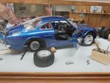 a blue toy car that is on display in a glass case