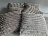 several pillows are stacked on top of each other on a white surface
