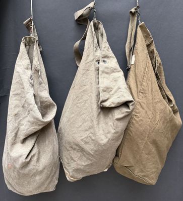 trois sacs suspendus à un crochet fixé au mur