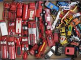 une boîte remplie de camions de pompiers et de camions miniatures