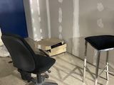 une chaise noire et un bureau noir dans un coin de la pièce