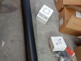 a black pipe laying on the floor next to boxes