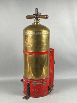 an old brass fire extinguisor with a red handle on a white background