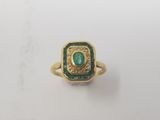 a close up of a gold ring with a green stone