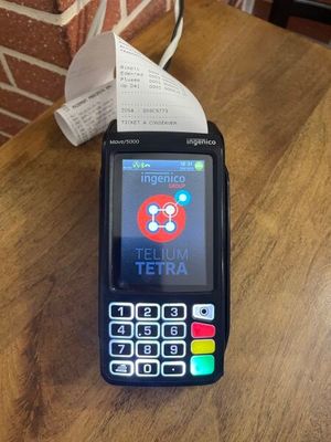a cell phone sitting on a table with a receipt in front of it