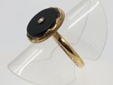 Gros plan sur une bague en or ornée d'une pierre noire