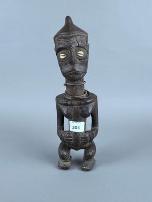 figurine en bois représentant un homme avec une pancarte sur la poitrine