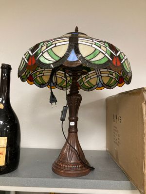 a lamp that is sitting on a shelf next to a bottle of wine