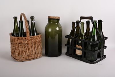 Des bouteilles et un panier sont posés l'un à côté de l'autre sur une table