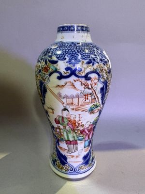 a blue and white vase with a picture of people on it