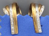 pair of gold and diamond earrings on a blue piece of cloth