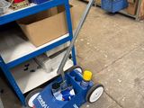 un chariot bleu sur lequel se trouve une balle jaune, dans un entrepôt