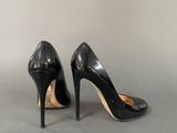 a pair of black high heeled shoes sitting on top of a table