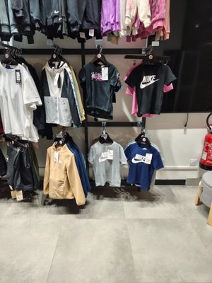 beaucoup de vêtements suspendus à un mur dans un magasin
