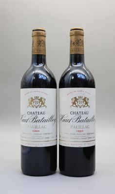 deux bouteilles de vin sont posées sur une surface blanche