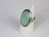 a close up of a ring with a green stone in it