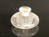 a small glass candle holder on a black surface